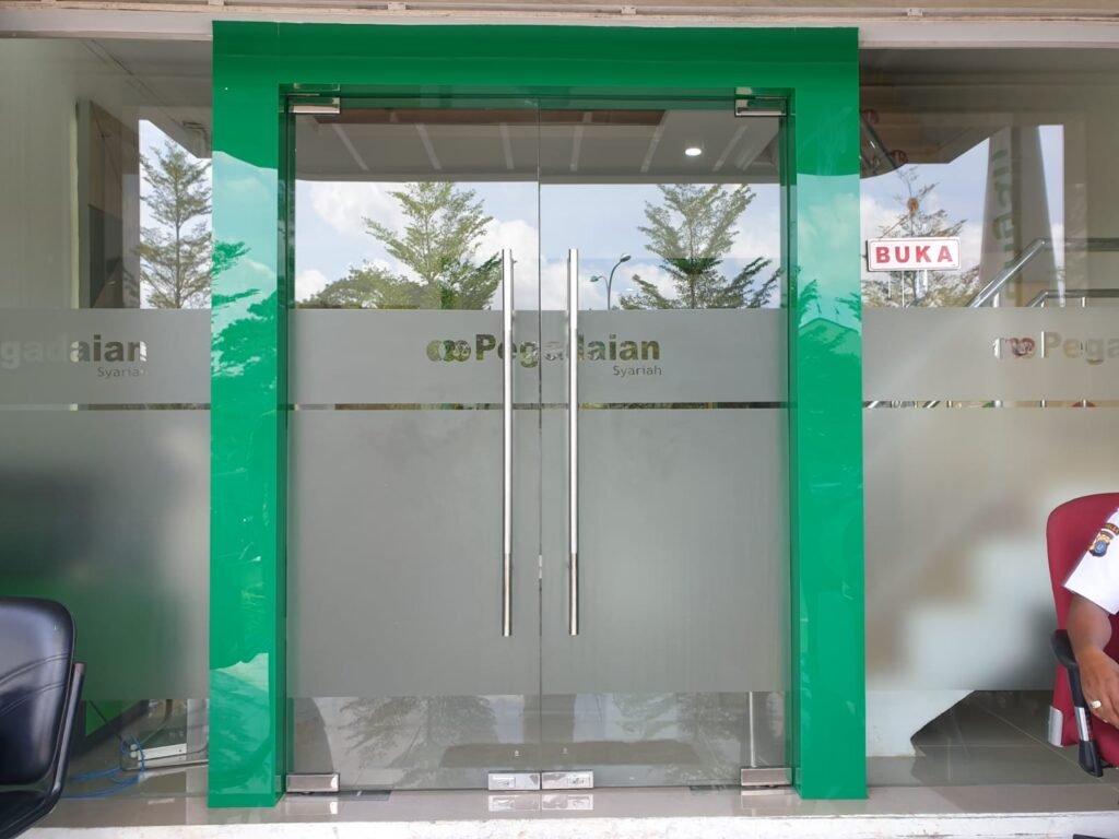Pintu kaca dengan stiker sandblast di pintu masuk Pegadaian Cabang Sei Panas Batam