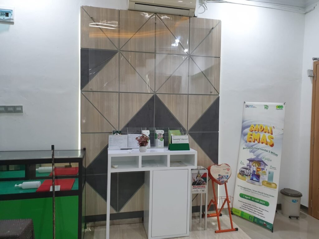 Panel dinding dekoratif dan meja brosur di ruang layanan Pegadaian Cabang Sei Panas Batam